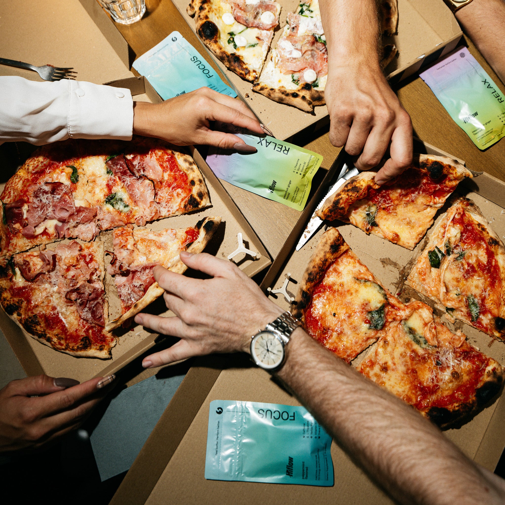 People eating pizza amongst Hiflow gum packages