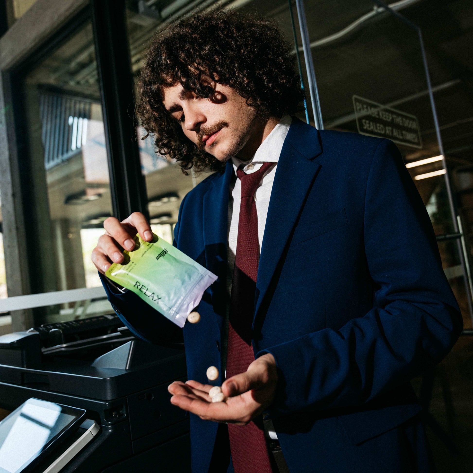 Man in a suit holding a Hiflow Relax gum pouch.
