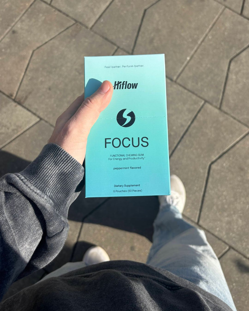 A person's hand holding a Hiflow Focus gum box.