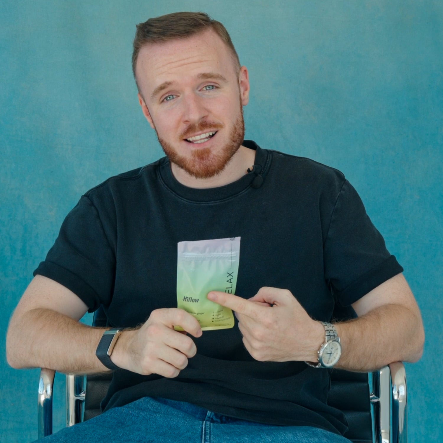 The picture shows Hiflow's founder holding a Relax gum in his hand, sitting on a chair with a light blue background.