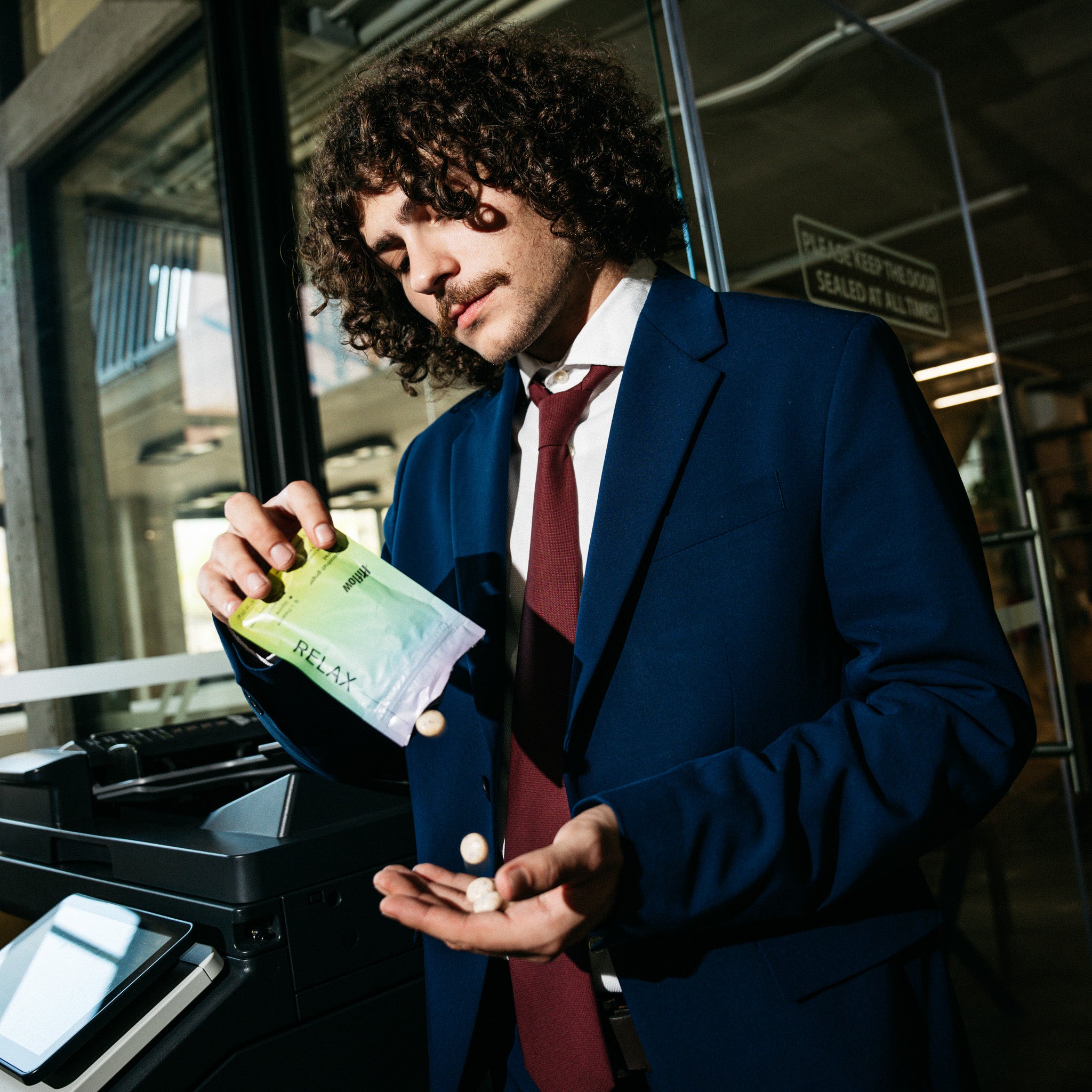 Guy in a suit holding Hiflow Relax gum pouch.